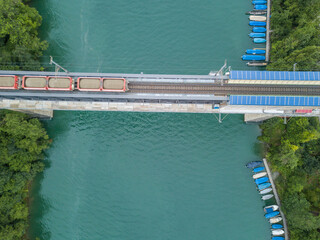 Aerial view of railroad bridge with cargo train over river in Switzerland