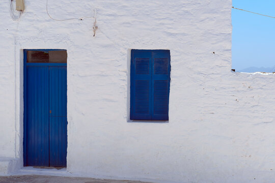 Traditional aegean greek island buildings, houses of greece islands, white walls, blue windows and doors, travelling concept