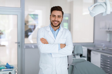 Young man dentist posing at dental cabinet - obrazy, fototapety, plakaty
