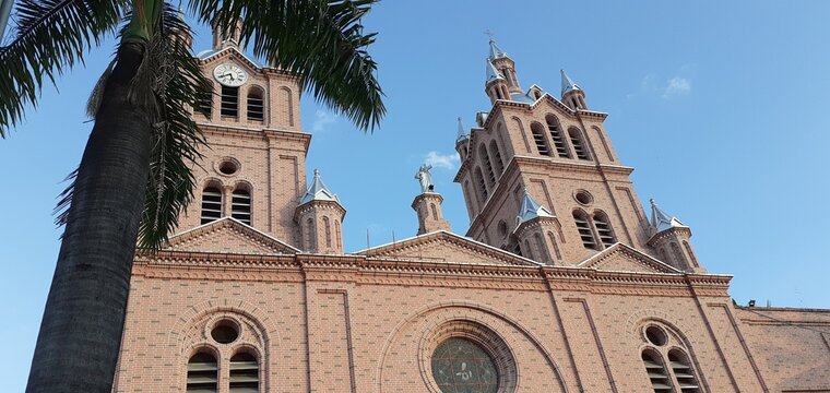 Torres de reloj de la bas&iacute;lica de Guadalajara de Buga y palmera.
