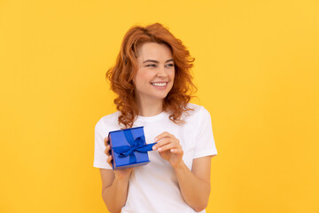 laughing woman with present box on yellow background, birthday