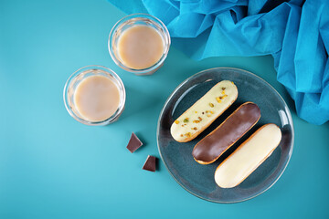 Fresh multicolored eclairs with chocolate glaze