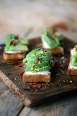 Selective focus. Delicious toast with avocado on a wooden board.