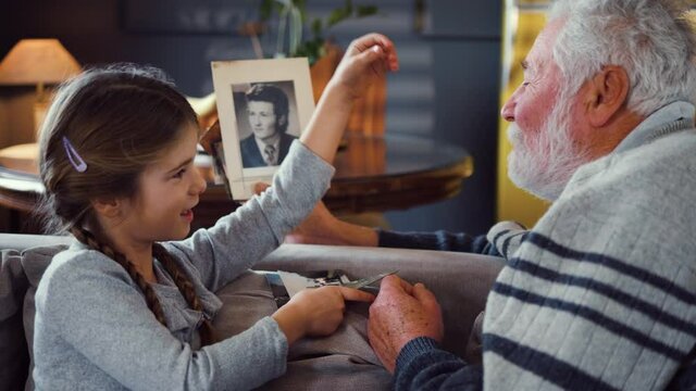 Granddaughter and grandfather look at old family photography