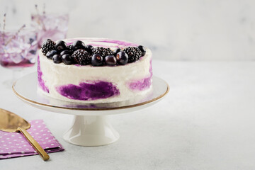 Beautiful tasty cake with white cream and blueberries on cake stand