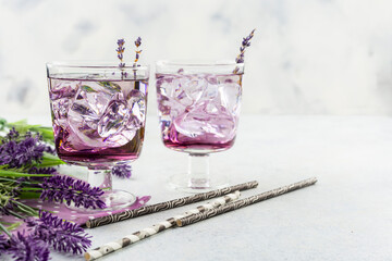 Purple cocktail drink in a glasses on white background with flowers