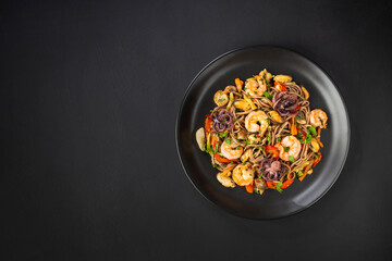 whole grains Pasta Spaghetti Seafood pasta in a black plate on concrete black background copy space