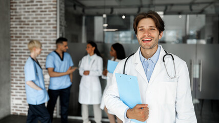 Handsome young doctor attending medical conference, smiling at camera, panorama