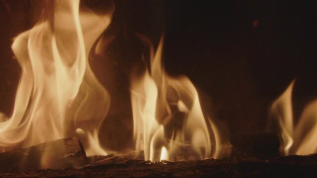 Textures of fire, embers and flames in slow motion inside a fireplace insert in a France house during winter.