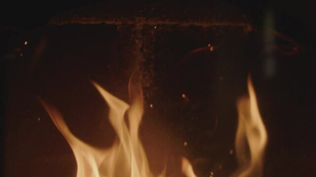 Textures of fire, embers and flames in slow motion inside a fireplace insert in a France house during winter.