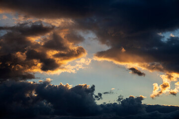 Dramatic cloudscape at sunset. Sunset with sun rays. Evening sky with dramatic clouds view. Gradient color. Sky texture, abstract nature background