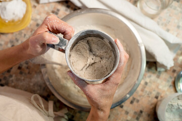 Young female preparing vegetarian bread dough on the table. Vegetarian meal concept. Close up.