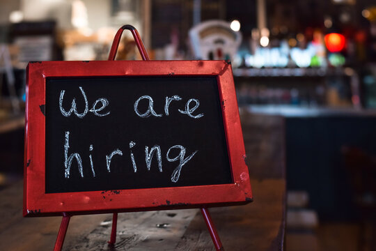 We are hiring sign on chalkboard  in a restaurant