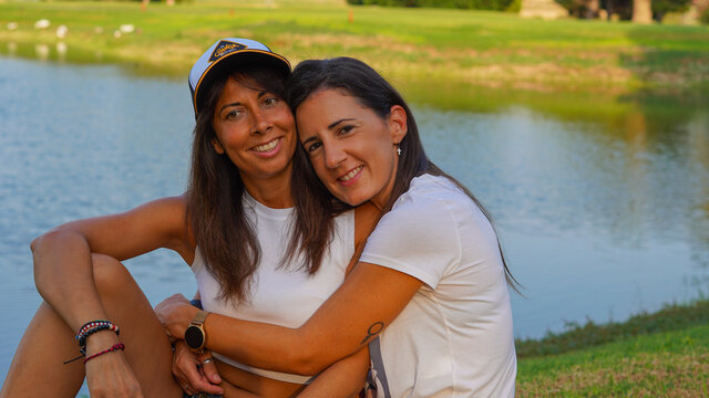 Chivas j&oacute;venes LGTB que son pareja y estan casadas enamoradas jugueteando en un campo de golf muy verde