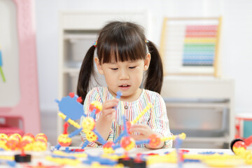 young girl playing creative 3d shape toy for homeschooling