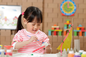 young girl painting  egg carton glasses craft at home