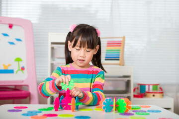 Fototapeta premium young irl playing creative toy blocks at home