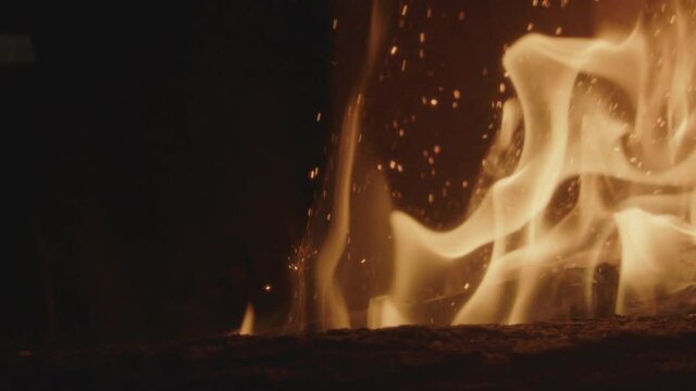 Textures of fire, embers and flames in slow motion inside a fireplace insert in a France house during winter.