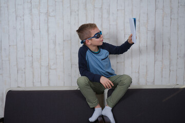 komiczny chłopak w okularach do pływania czyta książkę - obrazy, fototapety, plakaty