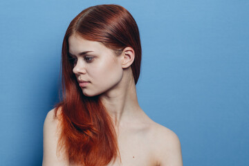 redhead woman naked shoulders hair care blue background