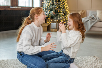 Sister's happy children laugh and chat. Winter holidays concept, merry christmas and family