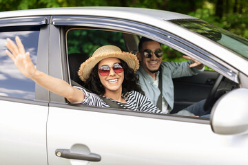 Cheerful middle-eastern loving couple going to beach by car