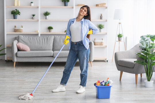 Portrait of tired woman suffering from backache after cleaning - Powered by Adobe