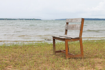 Obraz na płótnie Canvas The empty wood bench near the lake in the park on a sunny day.