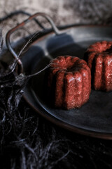 Caneles de bordeaux on dark background with sunrise. French pastry Canele rum and vanilla flavor thick caramelized crust