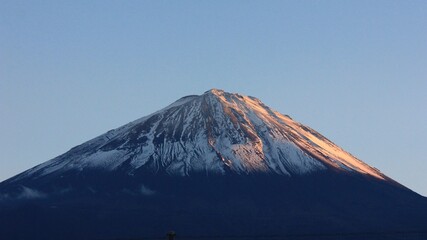 秋の夕暮れの冨士山。夕日に赤く染まる冨士。山梨県鳴沢にて。