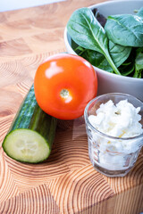 Closeup of a plate of salad, cucumber, tomatoes and Finnish cottage cheese.