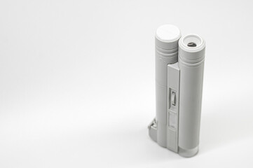 Compact mini microscope for printing and design. Magnifying device. Selective focus, copy space, white background