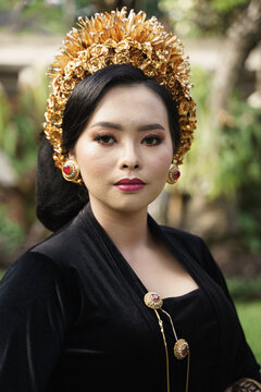 woman wearing Balinese kebaya with a tree as a background