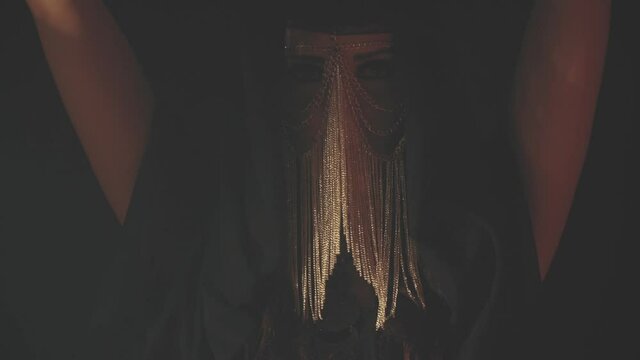 Woman in blinking light on black background in haze