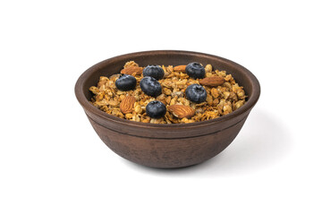 Deep clay bowl with muesli, berries and nuts isolated on a white background.