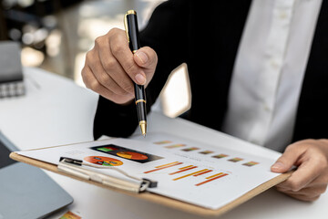 A business finance woman is reviewing a company's financial documents prepared by the Finance Department for a meeting with business partners. Concept of validating the accuracy of financial numbers.