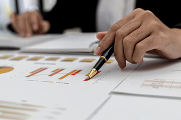 A business finance woman is reviewing a company's financial documents prepared by the Finance Department for a meeting with business partners. Concept of validating the accuracy of financial numbers.