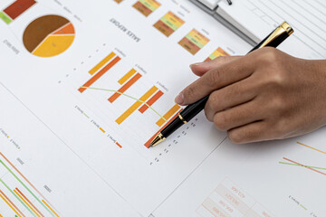A business finance woman is reviewing a company's financial documents prepared by the Finance Department for a meeting with business partners. Concept of validating the accuracy of financial numbers.