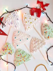 meringue in the form of Christmas trees decorated with sprinkles