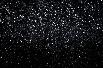 Many snowflakes in blur on black background. Snowfall layer for winter design