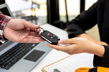Person holding the car key to the car rental company employee, the customer who has completed the...