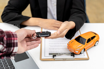 Person holding the car key to the car rental company employee, the customer who has completed the...