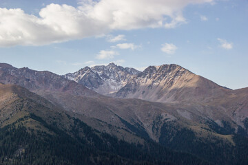 Beautiful Summer landscape: blue cloudy sky, green hills and distant mountains