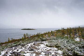 Russia. Magadan Region. A beautiful forest lake against the backdrop of the Big Anngachak mountain range. Autumn in the vicinity of Lake Jack London.