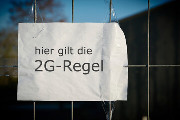 Schild am Zaun eines Veranstaltungsortes mit der Aufschrift hier gilt die 2G-Regel