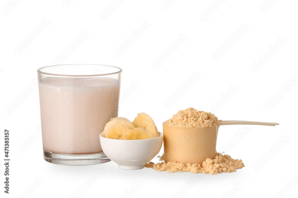 Wall mural Glass of protein shake, bowl with sliced banana and measuring scoop with powder on white background