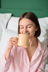 Morning of beautiful woman with cup of coffee in bedroom