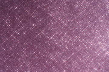 Abstract pink background with sparkles in the shape of stars.