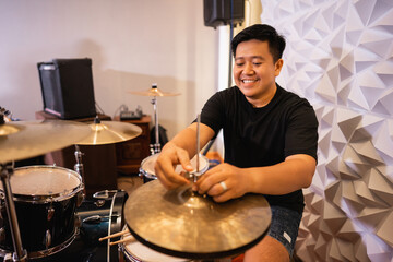 a male drummer prepares hi-hat cymbals before being used