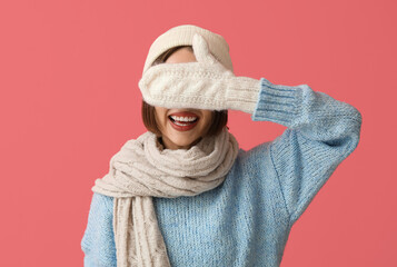 Happy young woman in stylish winter clothes on color background